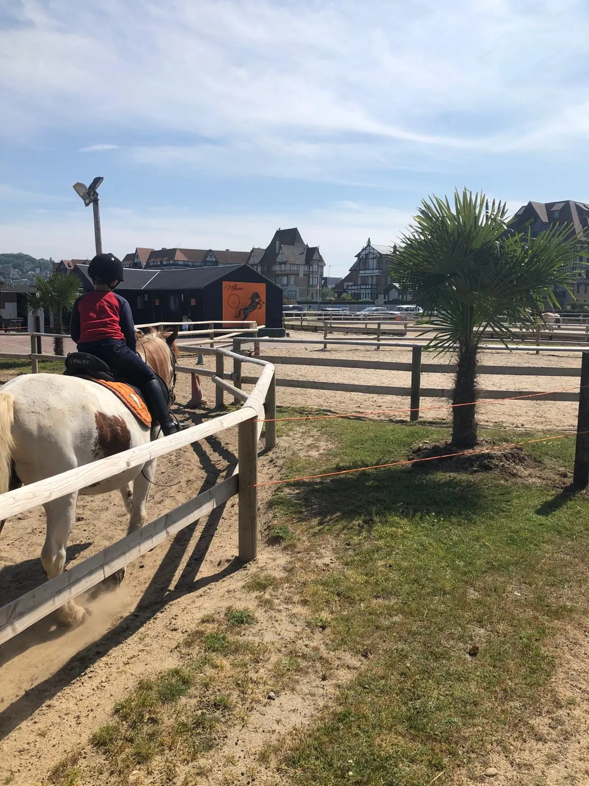 Un enfant à poney près des écuries du club